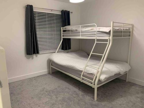 two bunk beds in a room with a window at Portrush Family Stay By The Beach 