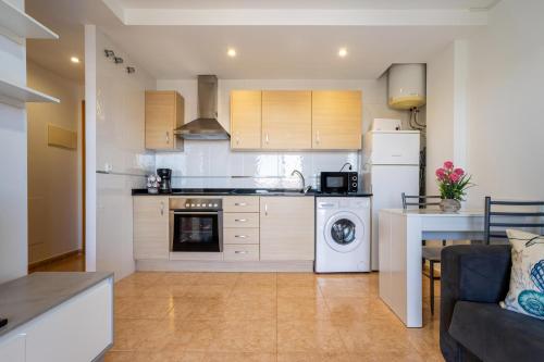 a kitchen with a washer and a stove top oven at Acrópolis Vidaber in Oropesa del Mar