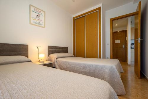 a hotel room with two beds and a doorway at Acrópolis Vidaber in Oropesa del Mar