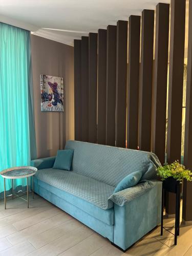 a living room with a blue couch and a table at Wellconect in Kutaisi