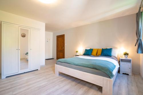 a bedroom with a bed with blue and yellow pillows at Pension Marie in Český Krumlov