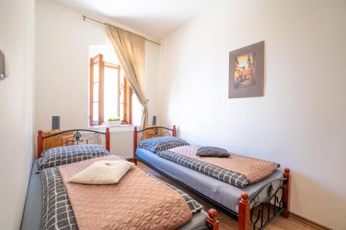 two twin beds in a room with a window at Pension Marie in Český Krumlov