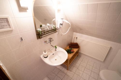 a white bathroom with a sink and a toilet at Pension Marie in Český Krumlov
