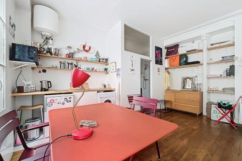 une pièce avec une table rouge et des chaises roses dans l'établissement Cosy studio just a stone's throw from Montmartre, à Paris