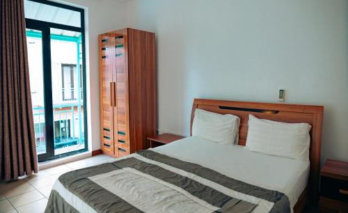 a bedroom with a bed and a large window at West Sand Holidays LICENSED BY THE TOURISM AUTHORITY 09926 in Flic-en-Flac