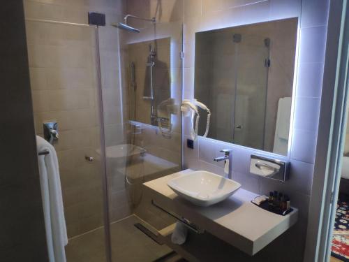 a bathroom with a sink and a shower with a mirror at Holiday Inn Telavi by IHG in Tʼelavi