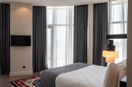 a bedroom with a bed and a large window at Holiday Inn Telavi by IHG in Tʼelavi
