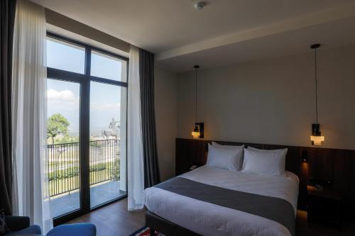 a bedroom with a bed and a large window at Holiday Inn Telavi by IHG in Tʼelavi