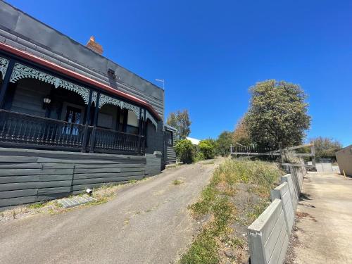 an empty road next to a black building at One-bed room the Little Mayfair in Daylesford