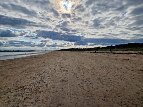 a sandy beach with a cloudy sky in the background at Banks Road in West Kirby