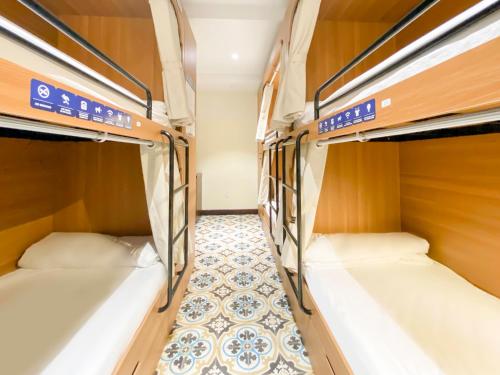 two bunk beds in a room with a tile floor at Hoi An Canal House Riverside By Haviland in Hoi An
