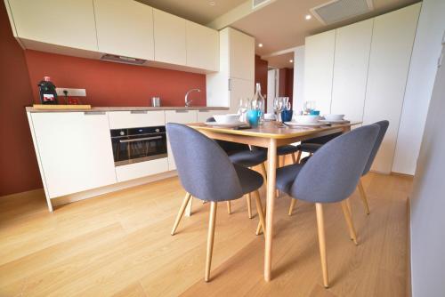 a kitchen with a wooden table and blue chairs at Résidence Kaliopé in Le Lavandou