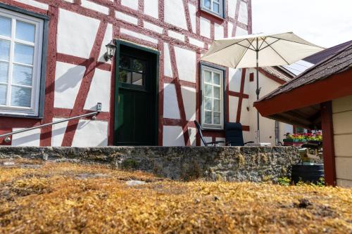 a house with a green door and an umbrella at Historische Ferienwohnung im Erdgeschoss in Lich