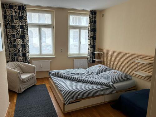1 dormitorio con 1 cama, 1 silla y 2 ventanas en Körner Nr 1 - ABC27, en Wismar