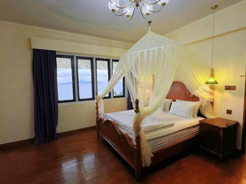 a bedroom with a bed with a mosquito net at VELAMUNDi INN Batu Ferringhi in Batu Ferringhi