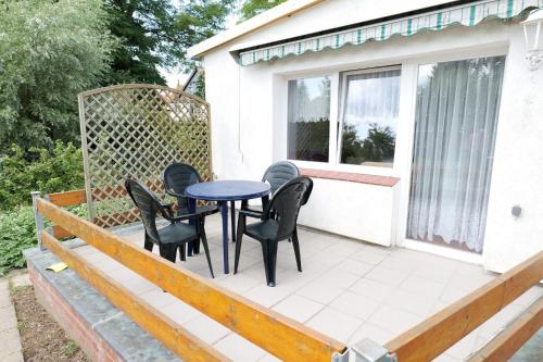 a deck with a table and chairs on it at Ferienbungalow Klützer Winkel - ABC165 in Klütz