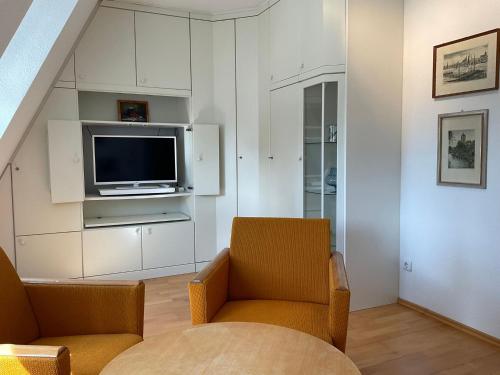 a living room with a tv and a couch and a chair at Marienkirche 2 - ABC336 in Wismar