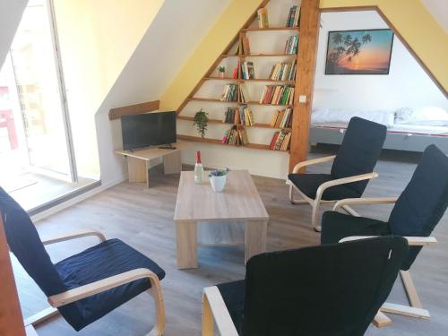 a living room with chairs and a table and a bed at Sonnendeck - ABC319 in Wismar