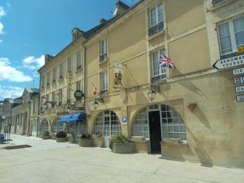 a large building with a flag on the side of it at Hostellerie Saint Martin- Logis Hôtel et Restaurant in Creully