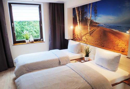 ein Hotelzimmer mit zwei Betten und einem großen Fenster in der Unterkunft Strandfeeling in Dahme