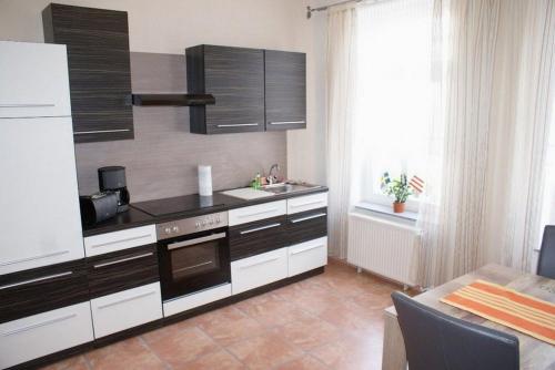 a kitchen with black and white cabinets and a sink at Altstadtappartement - ABC59 in Wismar