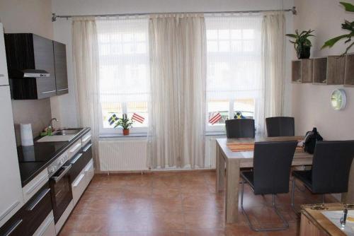 a kitchen with a table and chairs and a kitchen with windows at Altstadtappartement - ABC59 in Wismar