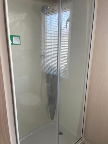 a shower with a glass door in a bathroom at Rockley Park Private Holiday Homes in Poole