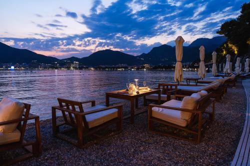 a row of tables and chairs next to a body of water at Dukley Hotel & Resort in Budva