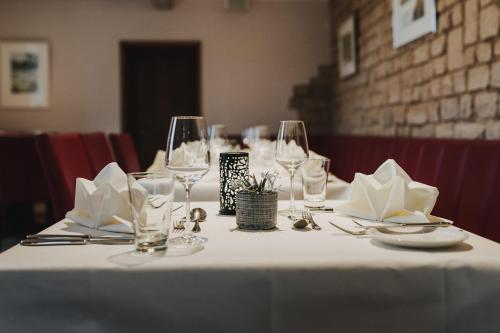 a table with wine glasses and napkins on it at Wein Erlebnis Hotel Maimühle in Perl