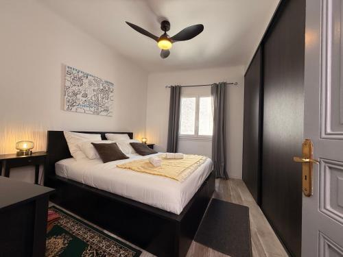 a bedroom with a bed with a ceiling fan at Le Peyrou - Elegant One-Bedroom Apartment for up to 4 Guests - Free Parking - Air Conditioning - Prime City Center Location in Montpellier