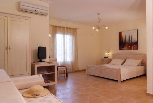 a bedroom with a bed and a tv in a room at Hotel Mediterranean in Stelida
