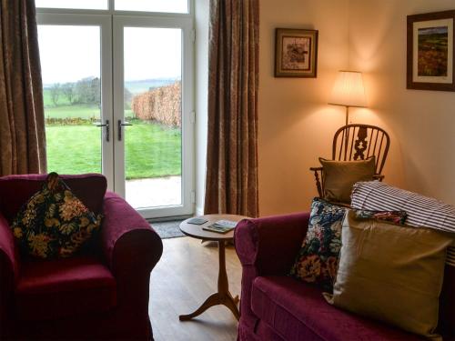a living room with a couch and a window at Croft Cottage in Sharperton