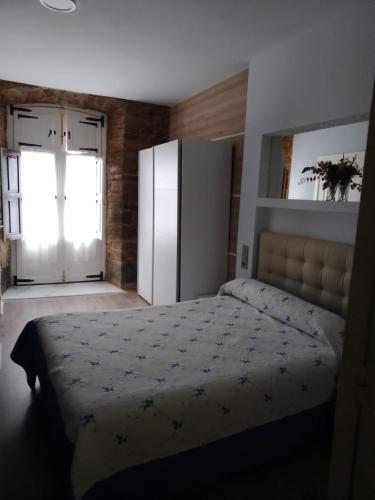 a bedroom with a large bed and a refrigerator at Hostal San Juan Oyarbide Tolosa in Tolosa