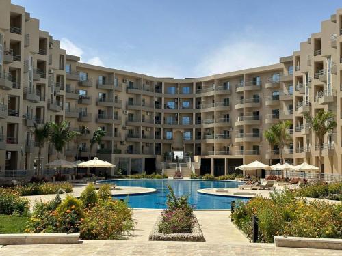 un grand immeuble avec piscine dans l'établissement Luxury Suite Princess Resort Two bedroom apartment Hurghada سويت فاخر البرنسيسه غرفتين, à Hurghada