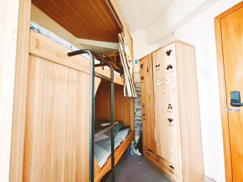 a small room with a bunk bed and a closet at 深圳市么么熊女生青年旅店 in Shenzhen