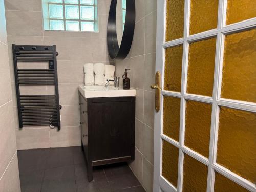 a bathroom with a sink and a mirror at Le Peyrou - Elegant One-Bedroom Apartment for up to 4 Guests - Free Parking - Air Conditioning - Prime City Center Location in Montpellier
