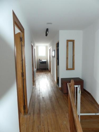 a hallway of an apartment with wooden floors and white walls at Gite 15 personnes in LʼAbsie