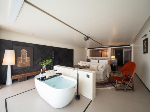 a bathroom with a bath tub and a bedroom at Lijiang Jijian Xiangwang SOOOAN Luxury Resort Hotel in Lijiang