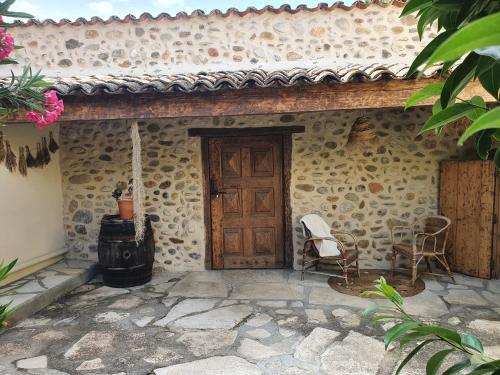 a stone house with a door and two chairs at La Bastide des Cyprès - La Parenthèse in Les Mées