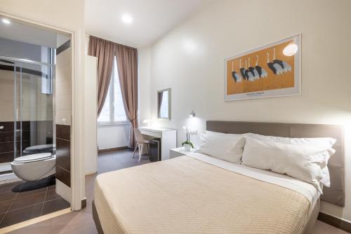 a bedroom with a large bed and a bathroom at Maison Trevi in Rome