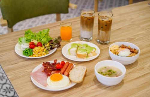 a table with plates of breakfast foods and drinks at Staybridge Suites Bangkok Sukhumvit by IHG in Bangkok