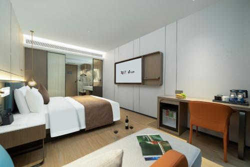 a hotel room with a bed and a tv at Yizhi Hotel - Guangzhou Shamian Island Huangsha Metro Station-Canton Fair free shuttle bus included Breakfast in Guangzhou