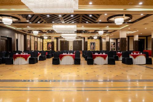 a banquet hall with black and red tables and chairs at Spectrum Resort, Spa & Residences in Udaipur