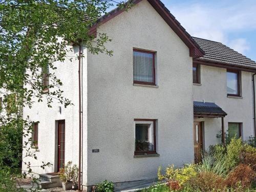a white house with brown windows at Lismore Cottage in North Ballachulish