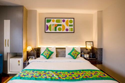 a bedroom with a large bed with colorful pillows at Treebo Golden Leaf in Rānchī