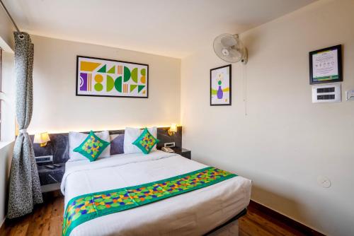 a bedroom with a large white bed with colorful pillows at Treebo Golden Leaf in Rānchī