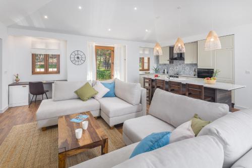 a living room with two couches and a kitchen at Camping Homes Mon Perin in Bale
