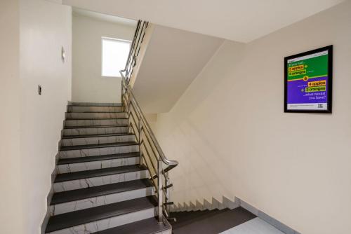a staircase in a white room with a window at Treebo Golden Leaf in Rānchī