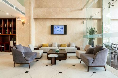 Un vestíbulo con un sofá y sillas y una mesa. en Galliot Hotel Nha Trang, en Nha Trang