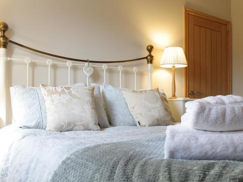 a bedroom with a white bed with white pillows at The Old Forge in West Lutton